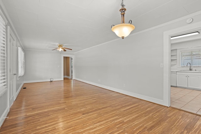 spare room with ceiling fan, light hardwood / wood-style flooring, ornamental molding, and sink