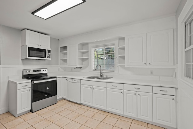 kitchen featuring sink, white cabinets, light tile patterned flooring, and white appliances