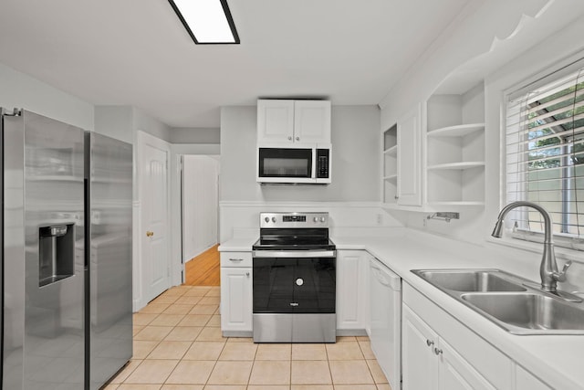 kitchen featuring light tile patterned flooring, stainless steel appliances, white cabinetry, and sink