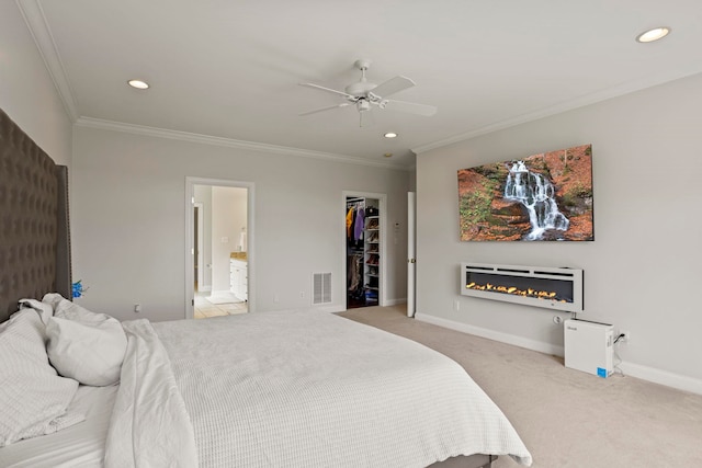 bedroom featuring visible vents, a spacious closet, ornamental molding, carpet flooring, and baseboards