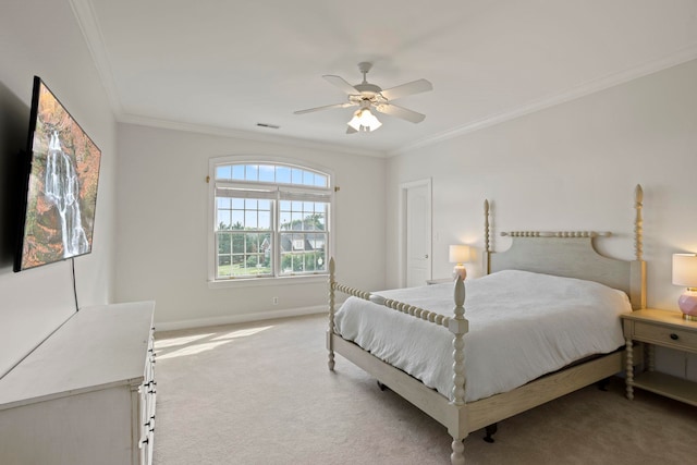 carpeted bedroom featuring a ceiling fan, baseboards, visible vents, and crown molding