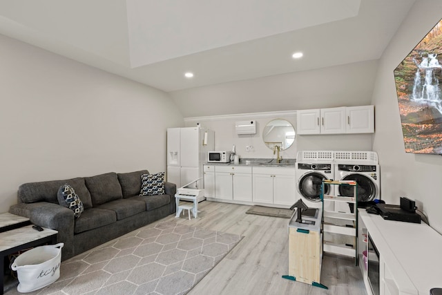 interior space with recessed lighting, vaulted ceiling, washer and clothes dryer, and light wood finished floors