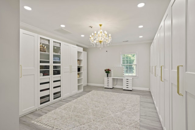 walk in closet featuring a chandelier, light wood finished floors, and visible vents