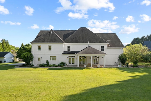 rear view of property featuring a yard, a patio area, and french doors