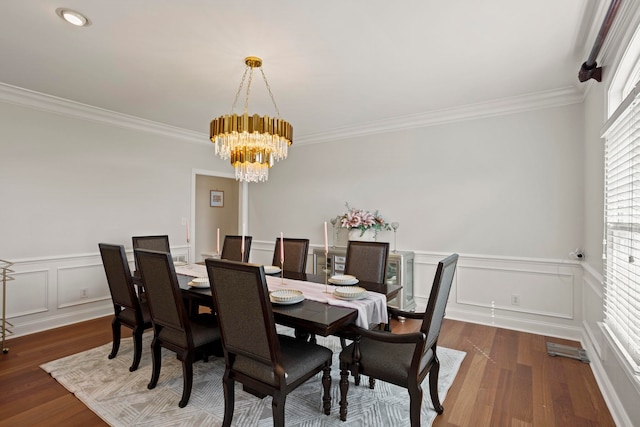 dining room featuring crown molding, a decorative wall, dark wood-style flooring, and an inviting chandelier