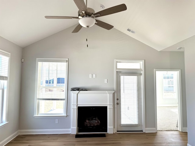 unfurnished living room featuring ceiling fan, vaulted ceiling, and hardwood / wood-style flooring