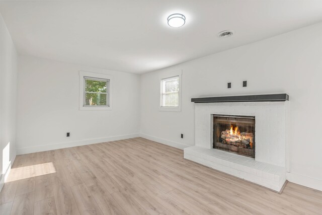 unfurnished living room with a fireplace and light hardwood / wood-style flooring