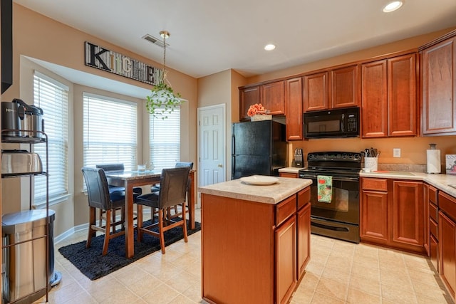 kitchen featuring pendant lighting, black appliances, a kitchen island, and light tile patterned floors