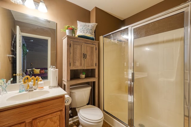 bathroom with toilet, vanity, and an enclosed shower