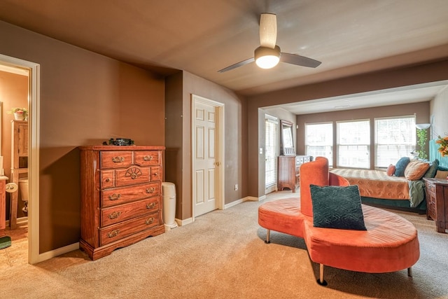 living area featuring ceiling fan, a healthy amount of sunlight, and light colored carpet