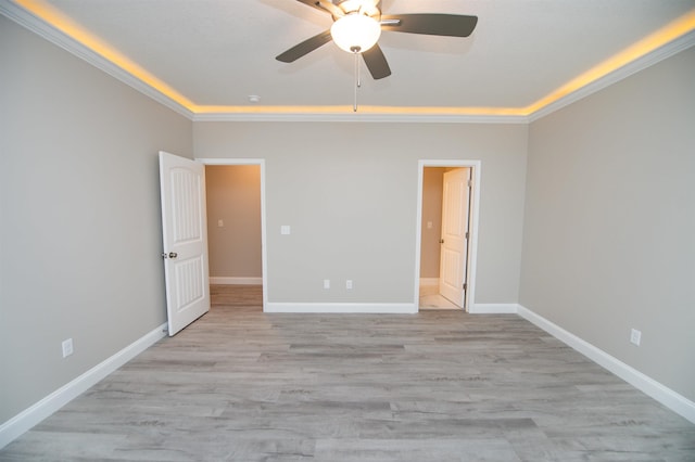 unfurnished bedroom featuring crown molding, light wood-style flooring, baseboards, and ceiling fan