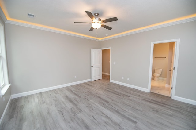 unfurnished bedroom featuring ornamental molding, baseboards, wood finished floors, ensuite bathroom, and ceiling fan