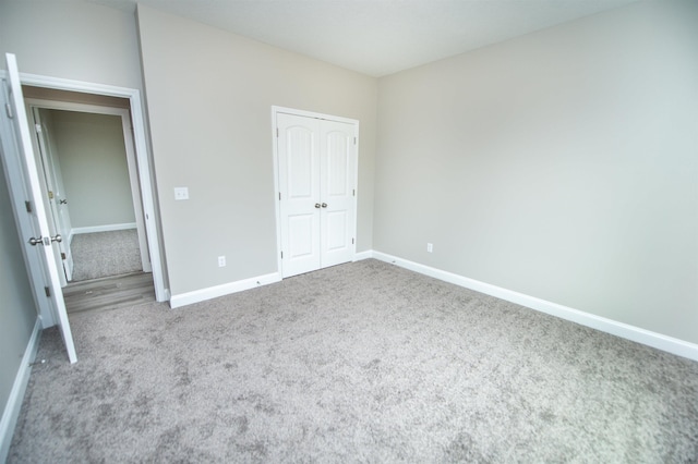 unfurnished bedroom with carpet, baseboards, and a closet