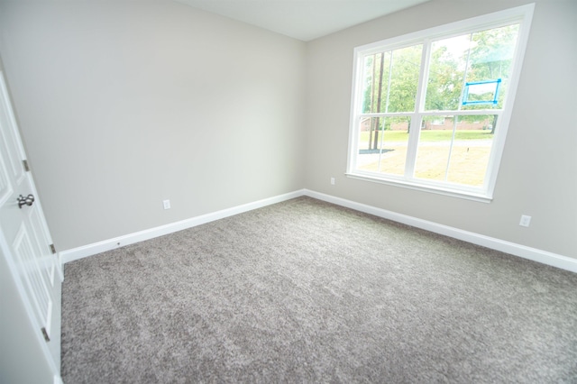 carpeted spare room featuring baseboards