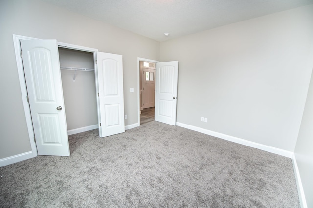 unfurnished bedroom with carpet floors, baseboards, and a closet