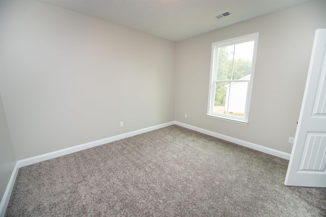 carpeted empty room featuring baseboards