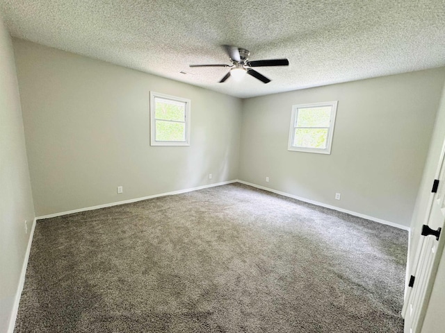 empty room with ceiling fan, plenty of natural light, carpet, and a textured ceiling