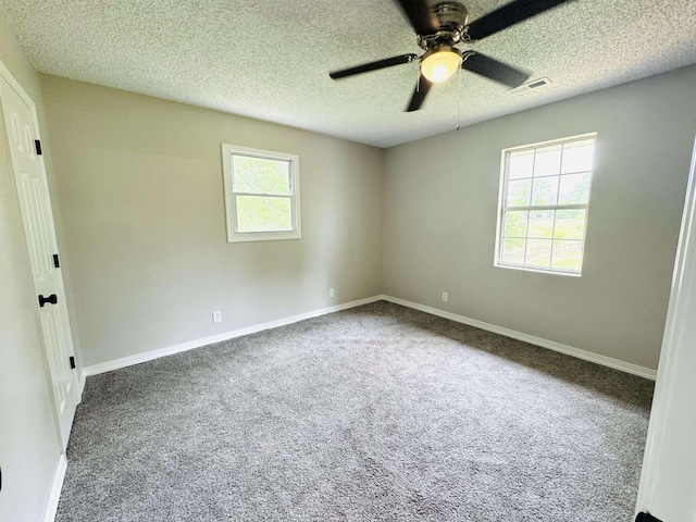 empty room with ceiling fan, carpet floors, and a textured ceiling