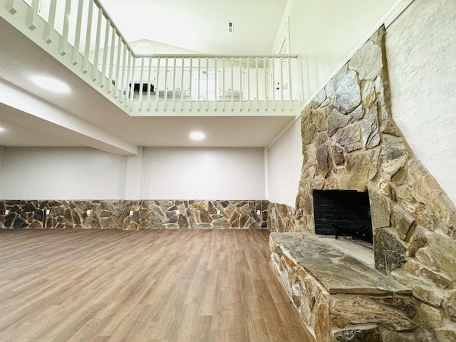 living room featuring a fireplace, hardwood / wood-style floors, and a towering ceiling