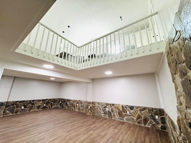 interior space featuring a high ceiling and hardwood / wood-style flooring