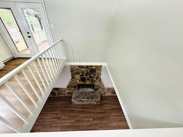 staircase with a fireplace, hardwood / wood-style floors, and french doors