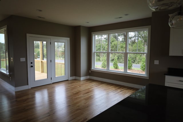 doorway to outside with a healthy amount of sunlight and hardwood / wood-style floors