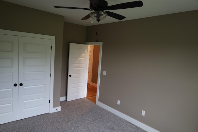 unfurnished bedroom featuring a closet, ceiling fan, and carpet flooring