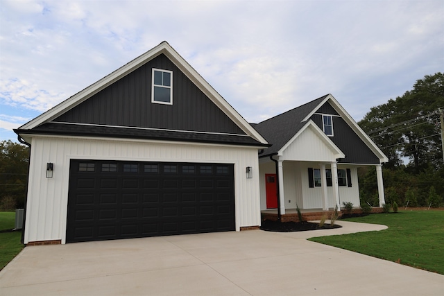 modern farmhouse with a front yard, driveway, a porch, a shingled roof, and a garage