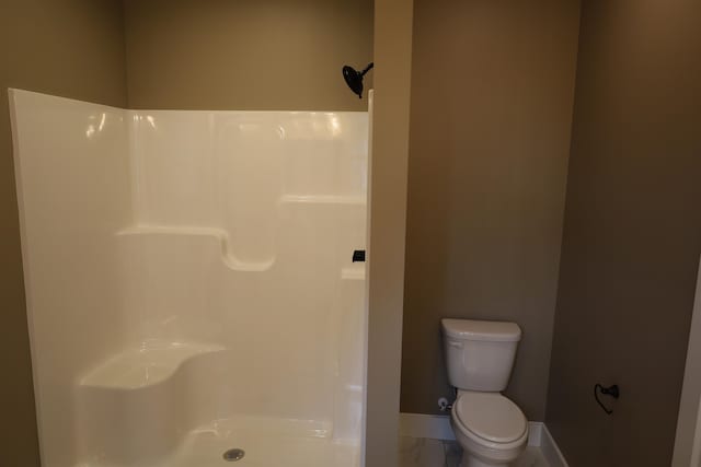 bathroom featuring walk in shower and toilet