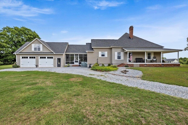 view of front facade with covered porch, a garage, and a front yard