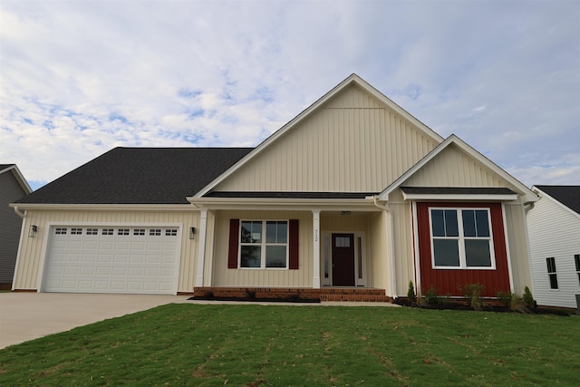 view of front of property featuring a garage, covered porch, and a front yard