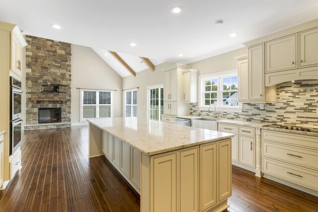 kitchen with stainless steel appliances, sink, a kitchen island, and cream cabinetry