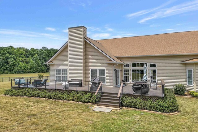 rear view of property with a deck and a lawn