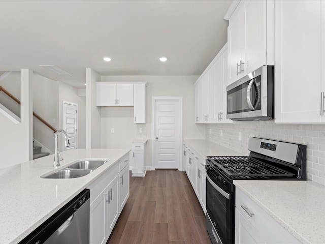 kitchen with sink, white cabinetry, stainless steel appliances, light stone counters, and tasteful backsplash