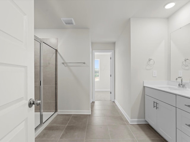 bathroom with vanity, a shower with shower door, and tile patterned floors