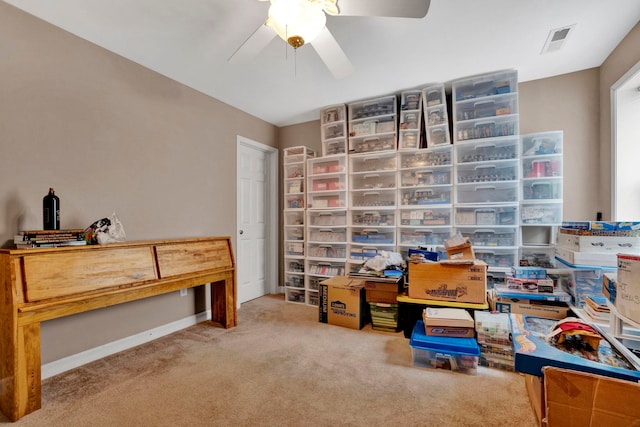 carpeted office space featuring ceiling fan