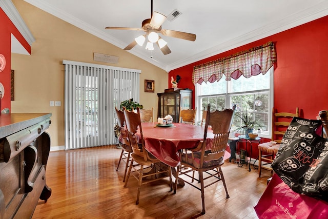 dining area featuring ceiling fan, lofted ceiling, wood-type flooring, and ornamental molding