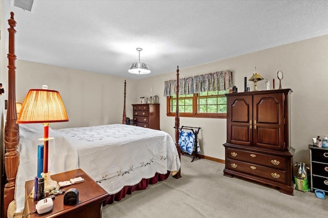 bedroom with light colored carpet and a textured ceiling