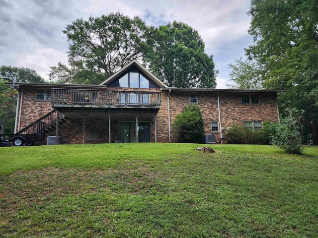 back of property featuring a deck, central air condition unit, and a yard