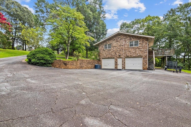 view of side of home with a garage and a deck