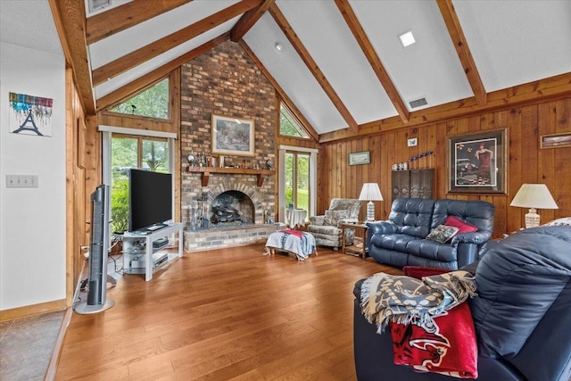 living room featuring a fireplace, plenty of natural light, beam ceiling, and high vaulted ceiling