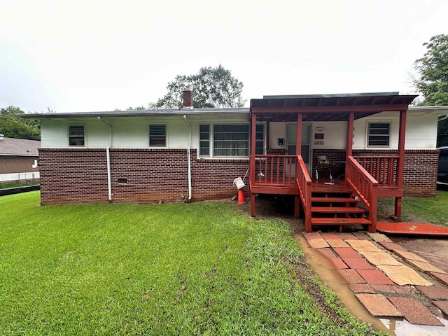 back of house featuring a deck and a lawn