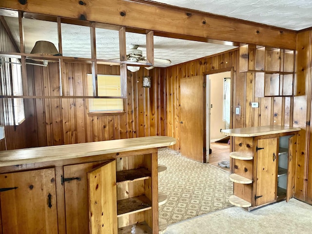 kitchen featuring open shelves, wooden walls, and a ceiling fan