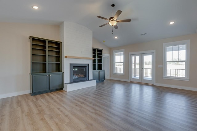 unfurnished living room with a fireplace, ceiling fan, french doors, light hardwood / wood-style floors, and lofted ceiling