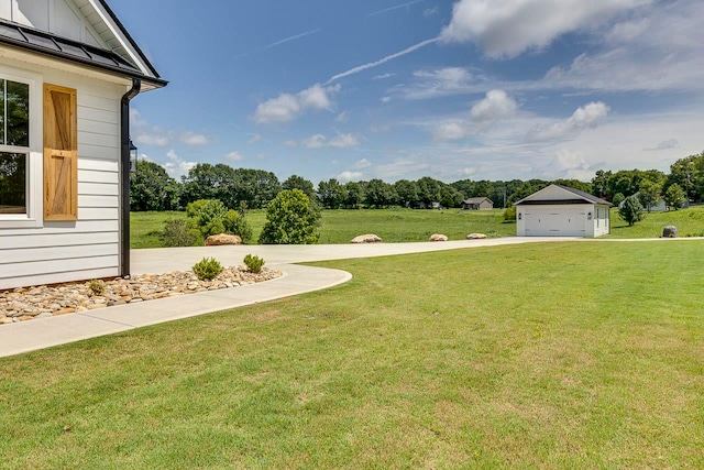 view of yard featuring a garage and an outbuilding