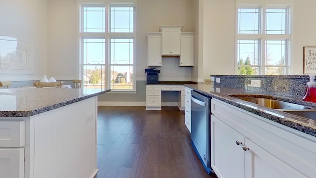 kitchen featuring dishwasher, a kitchen island, white cabinetry, dark stone counters, and dark wood-type flooring