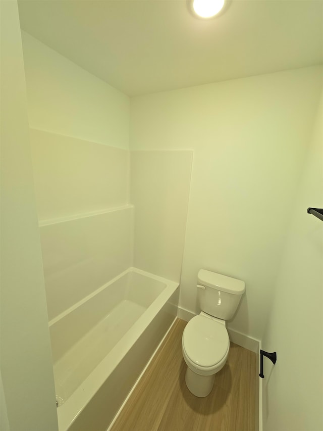 bathroom with wood-type flooring, toilet, and a bathtub