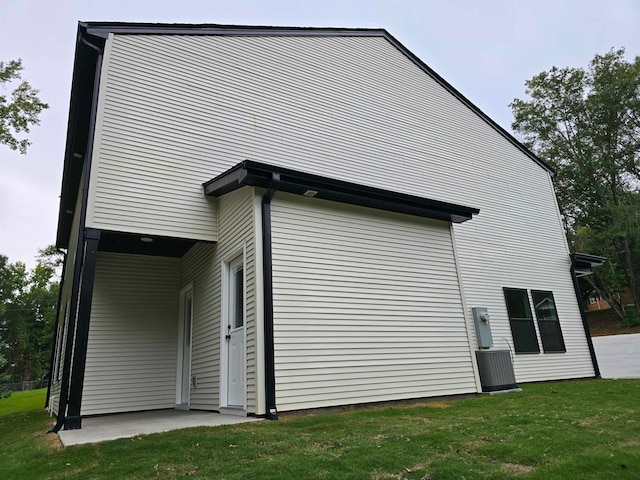 view of side of home featuring a yard and central air condition unit