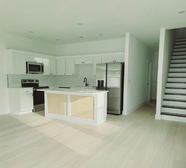 kitchen featuring white cabinetry, a kitchen island, and stainless steel appliances