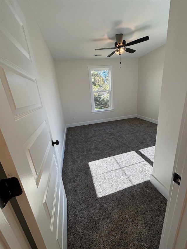 empty room featuring dark colored carpet